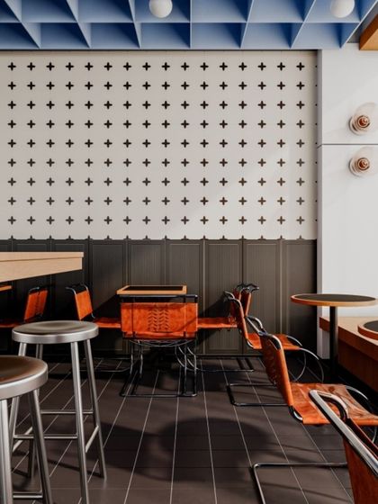 Our designer tiles used in a cafe setting. The simple cross pattern on the wall, paired with dark floor tiles, creates a chic and graphic look.