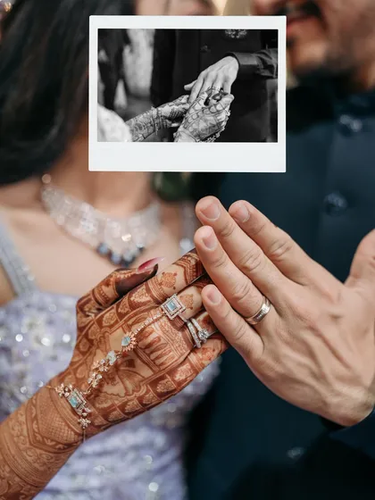 A focus on the hands, the rings, the promise. This creative shot layers a polaroid of the ring exchange over a close-up of their hands, symbolizing the moment their forever began.