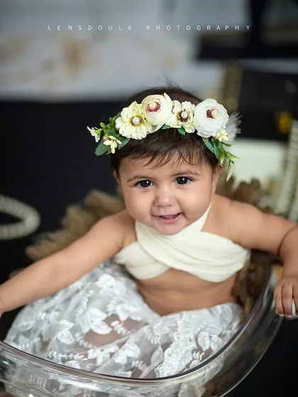 A happy smile from our little model. The floral headband and lace details add a touch of elegance to this stylish sitter session.