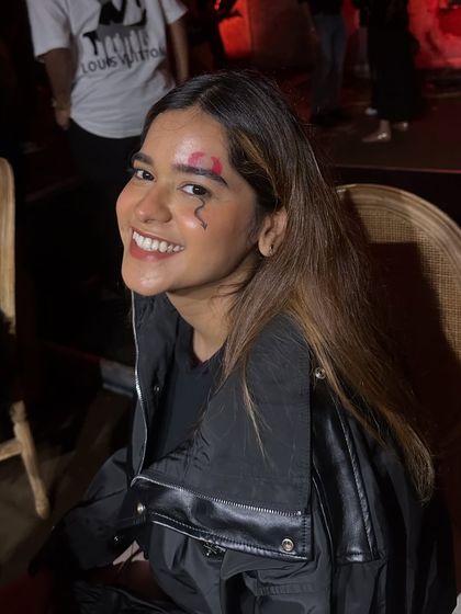 A happy client showing off her fresh SFX makeup, featuring a realistic wound and a small lightning bolt design on her forehead.