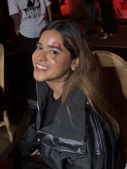 A happy client showing off her fresh SFX makeup, featuring a realistic wound and a small lightning bolt design on her forehead.