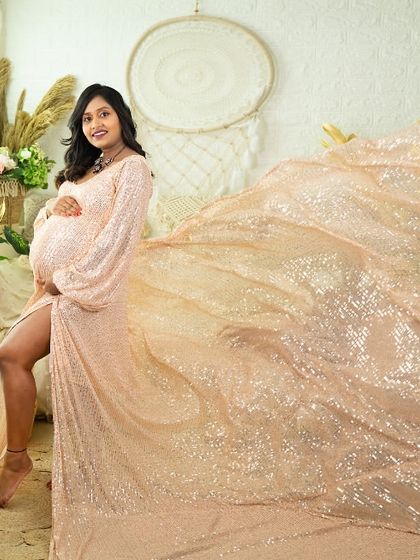 Shimmer and shine in this sequined gown with a flowing train. This portrait, taken in our boho-chic studio, captures a moment of glamour and elegance, using the light to make the fabric sparkle.