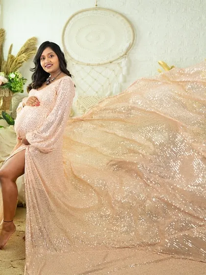 Shimmer and shine in this sequined gown with a flowing train. This portrait, taken in our boho-chic studio, captures a moment of glamour and elegance, using the light to make the fabric sparkle.