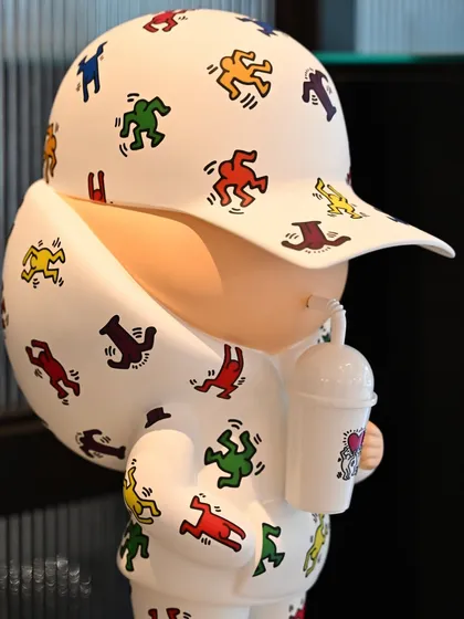 A close-up of the "Kid Cup" sculpture in the Keith Haring design, showing the detail of the pattern on the hoodie and cap.