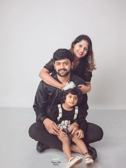 A lovely seated family portrait. The composition with mom hugging dad from behind creates a sense of closeness and unity.