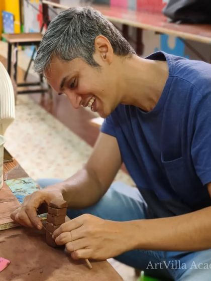 The smile of a happy creator. This participant is fully immersed in his project, enjoying every moment of the hands-on experience at our pottery workshop.