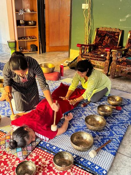 Two students work together to provide a full-body sound massage, a technique taught in our advanced workshops.