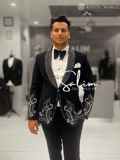 A client wearing a black tuxedo with intricate white and silver embroidery on the lapels and cuffs. The design is both classic and unique.