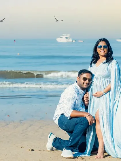 A tender moment on the beach, with the dad-to-be listening to the baby bump. A classic pose that is always full of love.