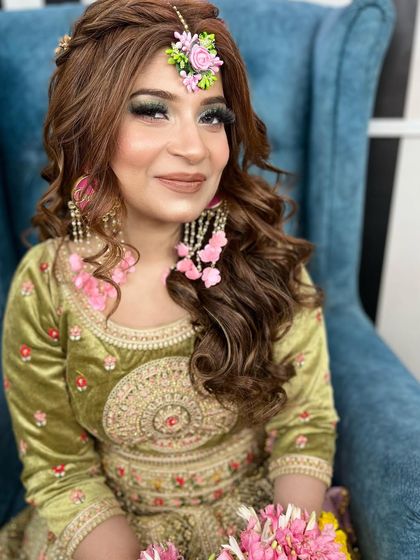 A gorgeous Mehendi look. I styled her hair with soft curls and a side part, finishing it with a beautiful floral maang tikka that matches her earrings.