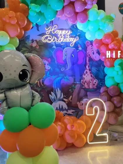 A vibrant jungle-themed second birthday with cute elephant and tiger foil balloons.