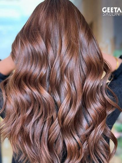 A beautiful copper-brown colour that looks vibrant and healthy, styled in classic waves.