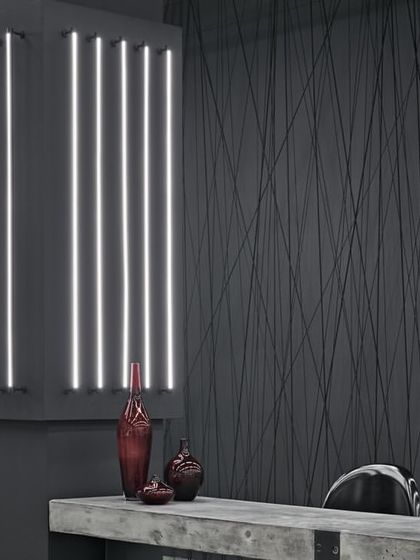 A wider shot of the showroom, highlighting the raw, industrial textures and the dramatic interplay of light and shadow. The design is edgy, raw, and sophisticated.