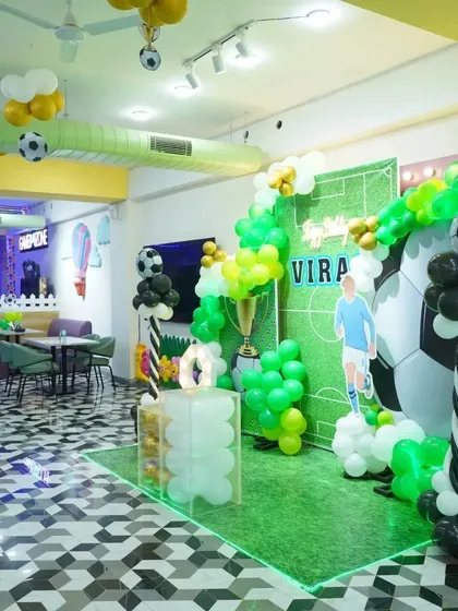 A wide shot of our venue during the football-themed party, showing the decorated photo-op area and the spacious cafe seating in the background.