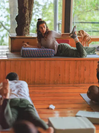 Demonstrating a gentle heart-opening pose from the front of the class. I often use bolsters to make the practice more restorative and accessible.
