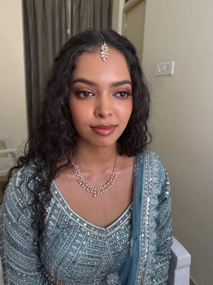 A close-up portrait of Sushmita, showing the details of her reception makeup. The look is all about glowing skin and beautifully defined eyes.