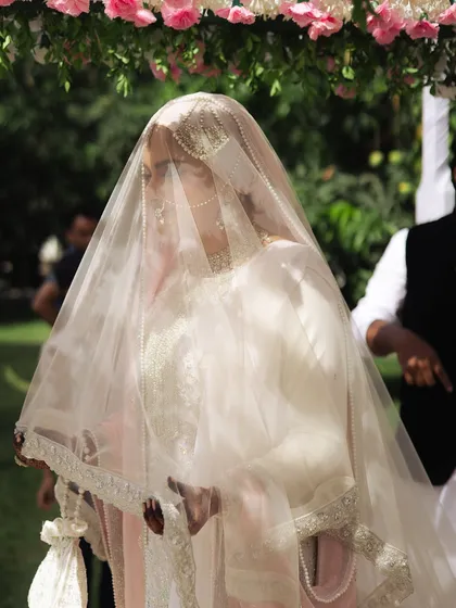 There is a certain magic in the quiet moments. Here, the bride makes her entrance during her Nikaah ceremony, veiled and graceful. We focus on capturing the reverence and beauty of traditions like these.