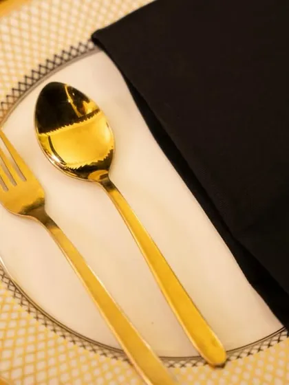 A close-up of a place setting featuring our gold-plated cutlery and fine china. These small details contribute to the overall sense of luxury and thoughtfulness that we bring to every table.