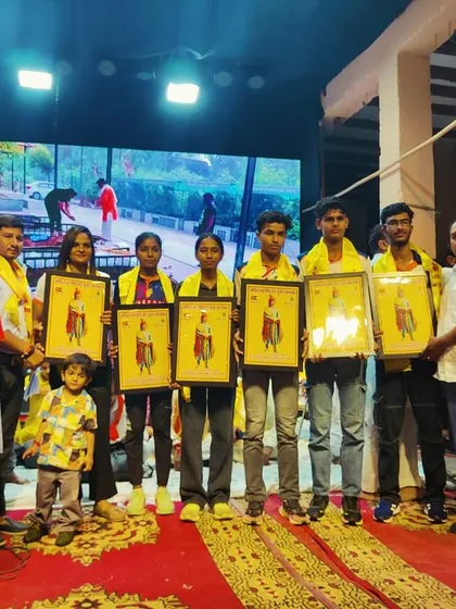 Our team of athletes being felicitated on stage during a community event celebrating their success in track and field.
