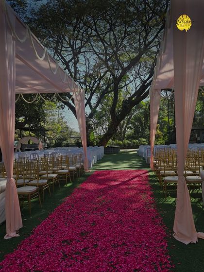 A simple yet elegant aisle setup with a rose petal path and draped canopy. Every detail is thoughtfully arranged to create a beautiful journey to the altar.
