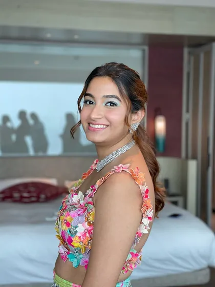 The client looking happy and vibrant. A ponytail is a great choice to show off the beautiful floral details on her blouse.