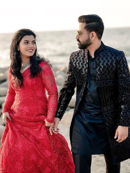 A beautiful engagement photo by the sea. The groom's black embroidered sherwani is both elegant and modern.