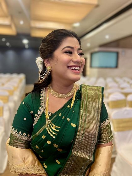Her smile says it all. This candid shot captures the joy of a bride feeling beautiful and confident in her traditional green saree look.