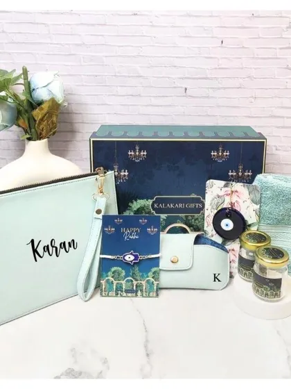 A personalized Rakhi hamper for him in a cool mint green theme. This set includes a custom utility pouch, an evil eye Rakhi, an eyewear case, a towel, and scented jars.