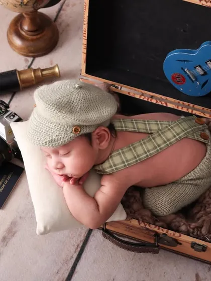 A different angle on adventure. This shot shows the full setup of the vintage traveler theme, with the newborn sleeping peacefully in a suitcase. It’s a highly creative and memorable concept.