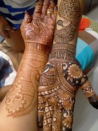A comparison of a fresh henna application and the resulting dark stain. This back hand design with a peacock and intricate patterns shows the beautiful color my henna develops into.