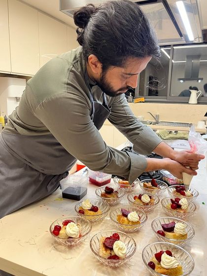 Assembling individual dessert bowls. Each portion is carefully piped and garnished, ensuring every guest receives a perfect final course.