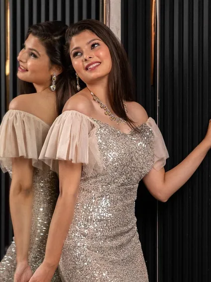 A joyful shot of a model in the silver mermaid gown. This dress is designed to make you feel confident and ready to celebrate.