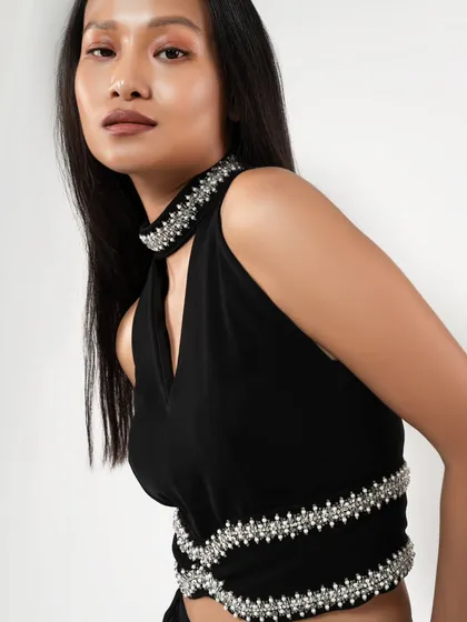 A close-up detail shot of a black top with pearl embellishments. This type of image is essential for e-commerce, showing customers the quality and unique features of the garment.