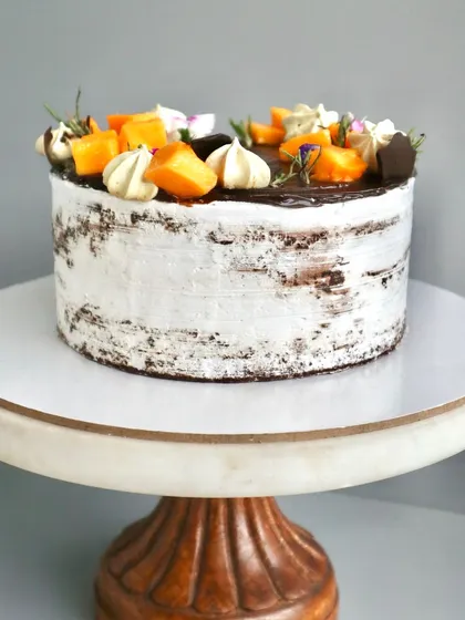 A side view of my Chocolate Mango Naked Cake, showing how the fresh mango chunks and light cream balance the rich chocolate sponge. It's a seasonal favourite.