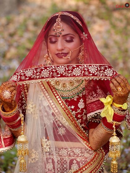 A close-up of the bride holding her veil, a classic and timeless pose that highlights the details of her dress and jewelry.