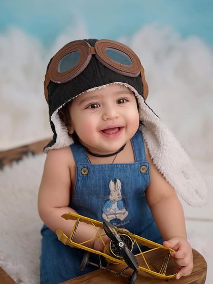 A close-up of our little aviator. The detailed props, like the goggles and toy plane, make our themed sessions immersive and fun.