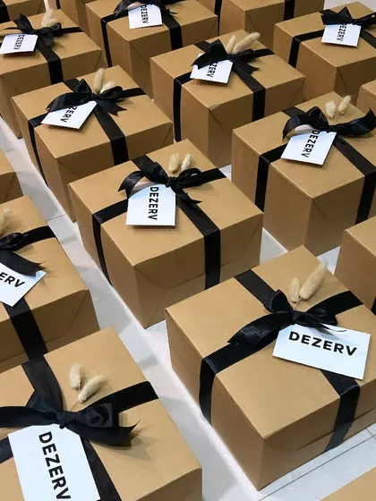 Simplicity and elegance define these corporate hampers for DEZERV. The minimalist kraft boxes with black ribbon and dried flower accents create a sophisticated and modern impression.