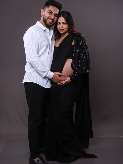 A classic full-length portrait of the couple. Her modern black saree and his simple white shirt create a timeless black-and-white theme that is both elegant and stylish.