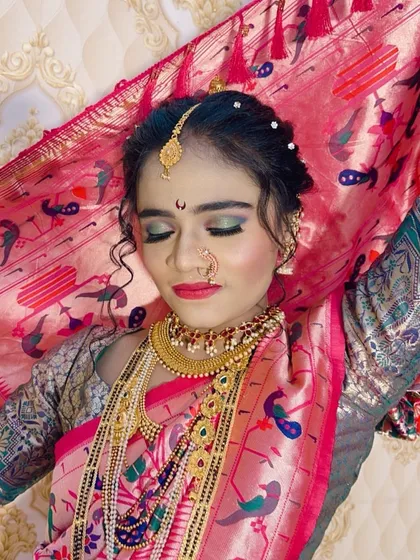 A beautiful shot of a Maharashtrian bride, showcasing the Paithani saree and the complete makeup look with shimmery green and gold eyeshadow.