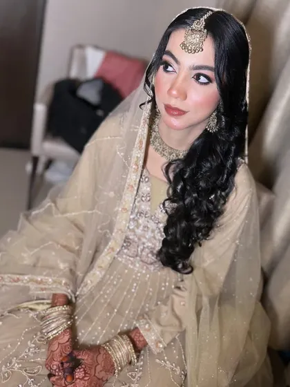 This bride's simple and elegant beige outfit was paired with soft makeup and beautiful side-swept curls.