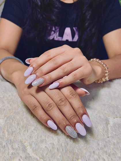 A lovely set of light purple almond-shaped extensions with a full-coverage silver glitter accent nail.