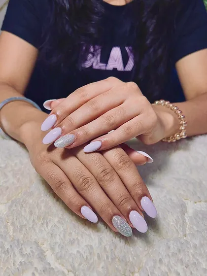 A lovely set of light purple almond-shaped extensions with a full-coverage silver glitter accent nail.