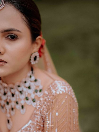 A close-up, artistic shot of the bride's face, focusing on her eyes and jewelry.