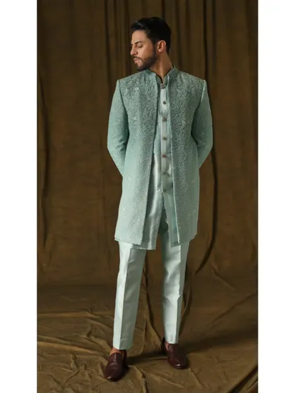 I designed this three-piece sherwani set in a refreshing mint green for a modern yet classic wedding look. The fully embroidered long jacket, paired with a matching inner kurta and trousers, is crafted from premium fabric to ensure both comfort and a commanding presence.
