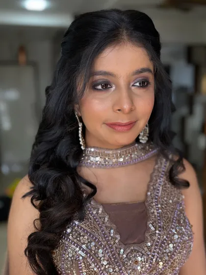 A soft and sultry look for an evening event. The makeup features a brown smokey eye and a nude lip, perfect for her embellished outfit.
