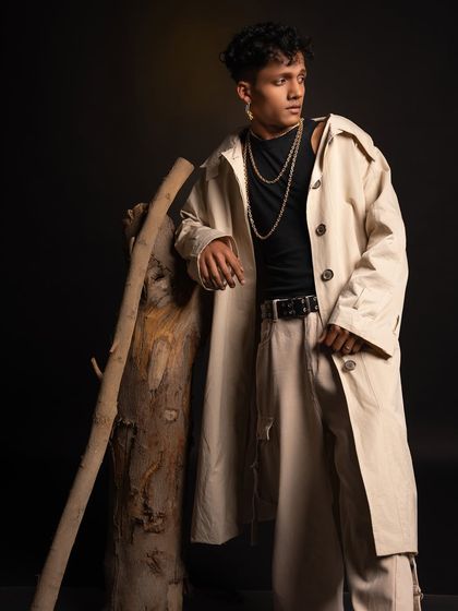 A full-length shot from the studio session, leaning against a wooden prop for a rustic yet fashionable feel.