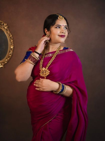 A stunning close up in a magenta saree. The intricate gold jewelry and traditional styling make this a vibrant and beautiful cultural portrait.