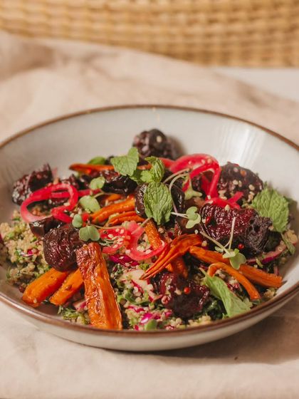 The Roasted Roots Salad, featuring a mix of oven-roasted beets and carrots on a bed of quinoa and fresh herbs, all tied together with a tangy lemon basil dressing.