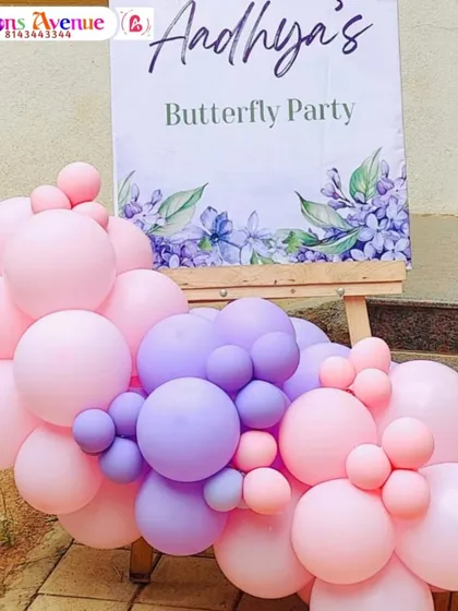 A welcome sign for Aadhya's Butterfly Party, decorated with a lovely pink and purple balloon garland.