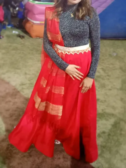 A full-length shot of the client in the red skirt, showing how the dupatta is draped to complete the indo-western look. A great rental option for a fun, festive occasion.